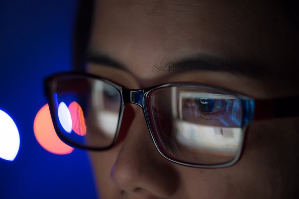 Mädchen mit Brille schaut auf einen Screen