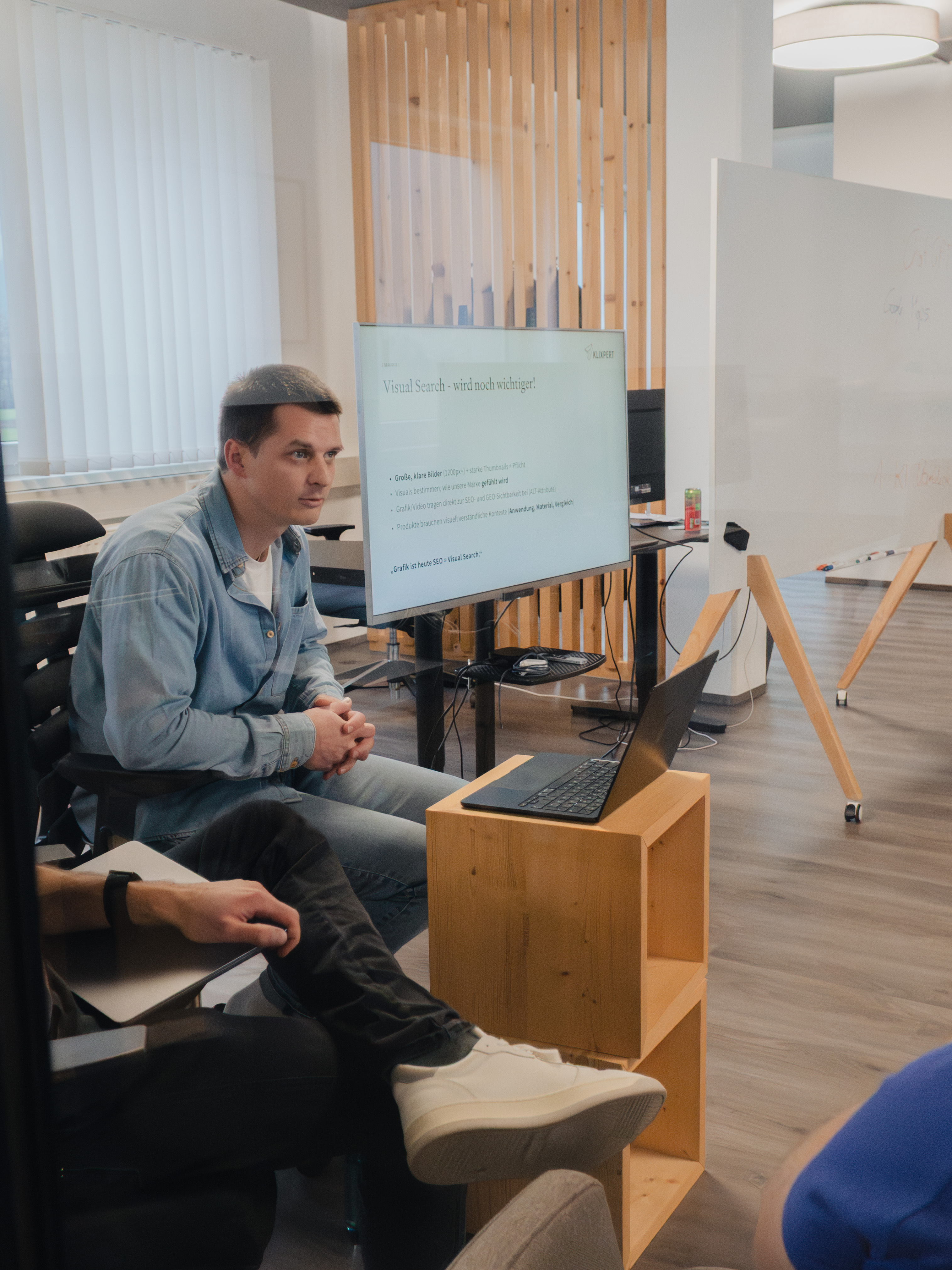 Zuhörer im Büro vor einem Bildschirm mit der Folie „Visual Search – wird noch wichtiger!“.