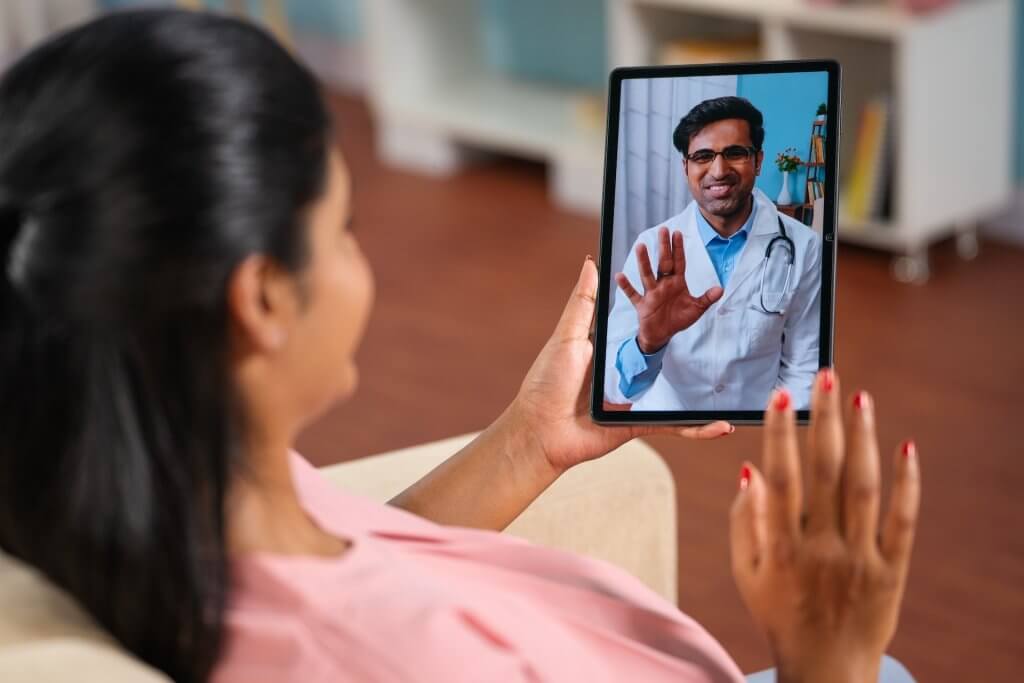 Frau schaut Video von einem Augenarzt auf ihrem Tablet